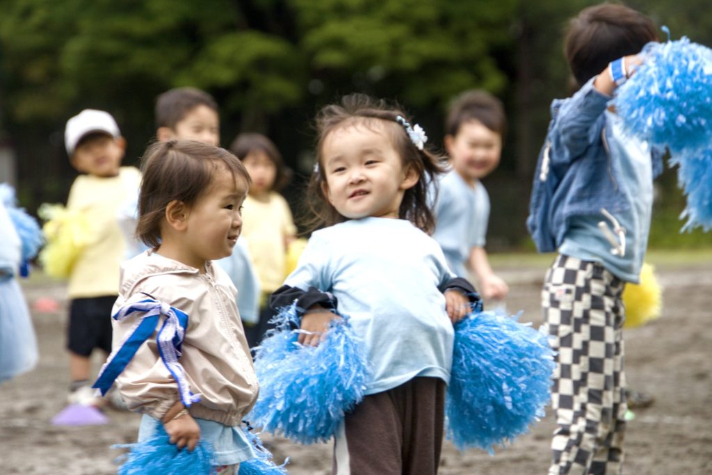 Sports Festival 2026で、青と白のポンポンを持って笑顔で踊る子どもたち