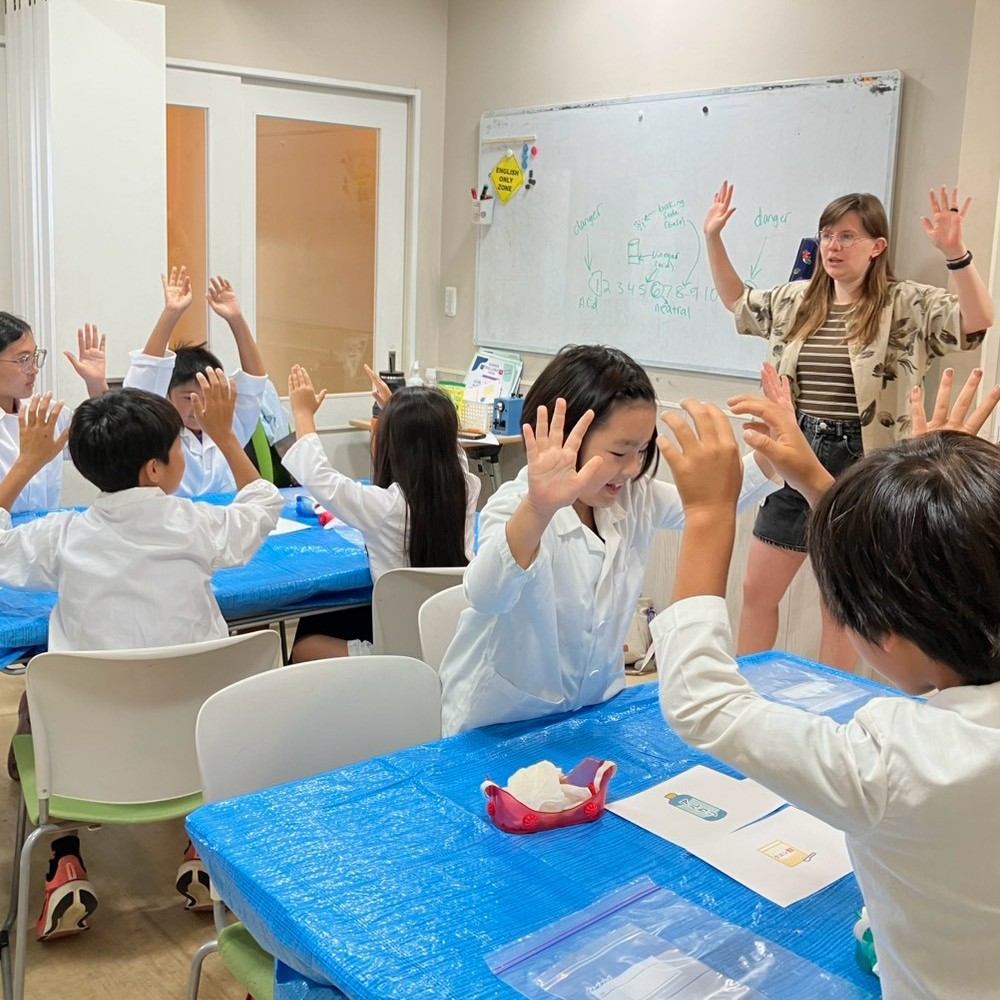 サマースクールで小学生が実験の説明を聞く様子