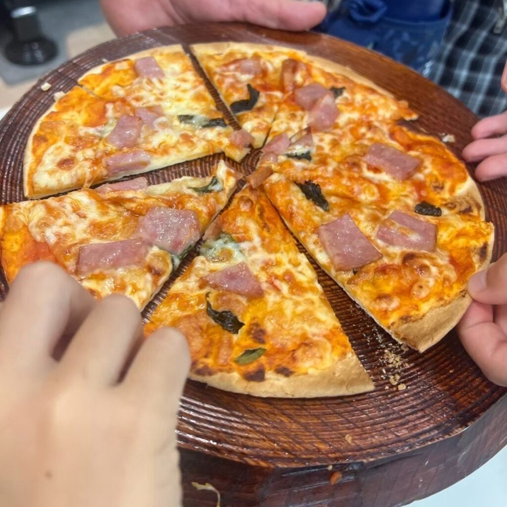 英語でピザ作りに挑戦!具材を自由にトッピングする子どもたち