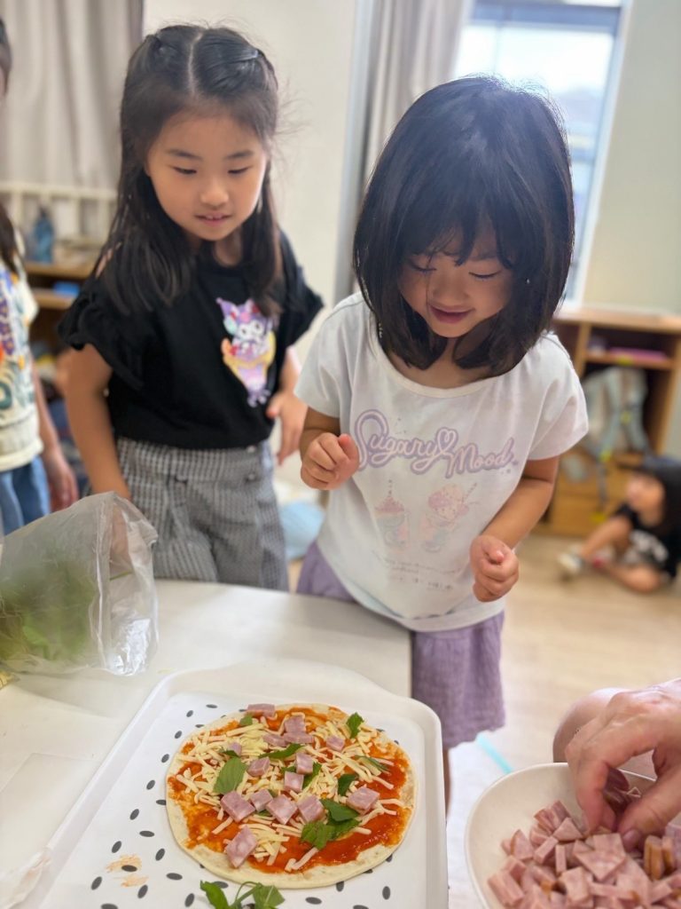 英語でピザ作りに挑戦!具材を自由にトッピングする子どもたち